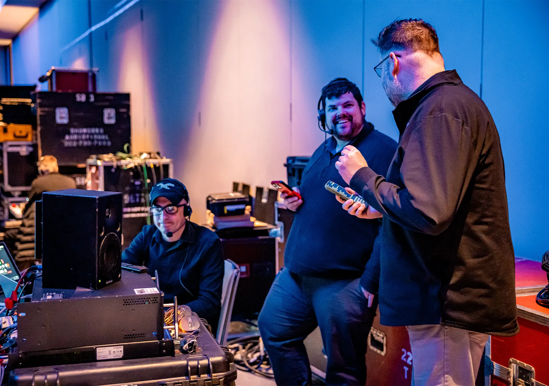 Backstage AV crew coordinating with radios and phones during a live show, reflecting how AI in AV production supports real-time communication and workflow.