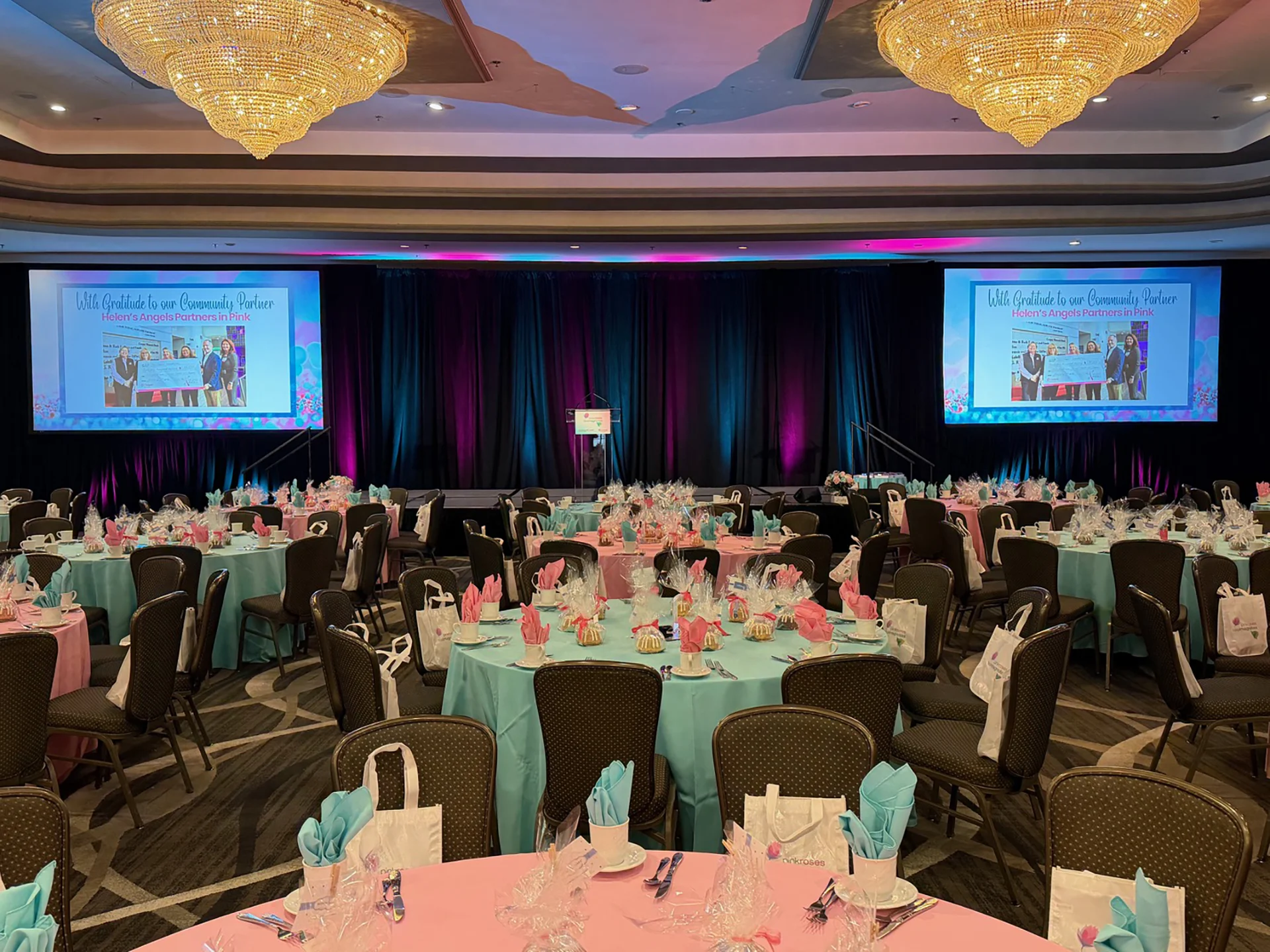Showorks AV, an AV production company Philadelphia, sets twin screens and pink-and-teal lighting for a community partner gala.